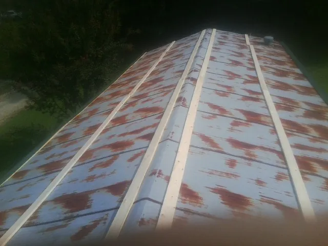 Rusted metal roof panels with new wood purlins before replacement — Storm Damage Roof Repair in Alloy by Roofing Brothers