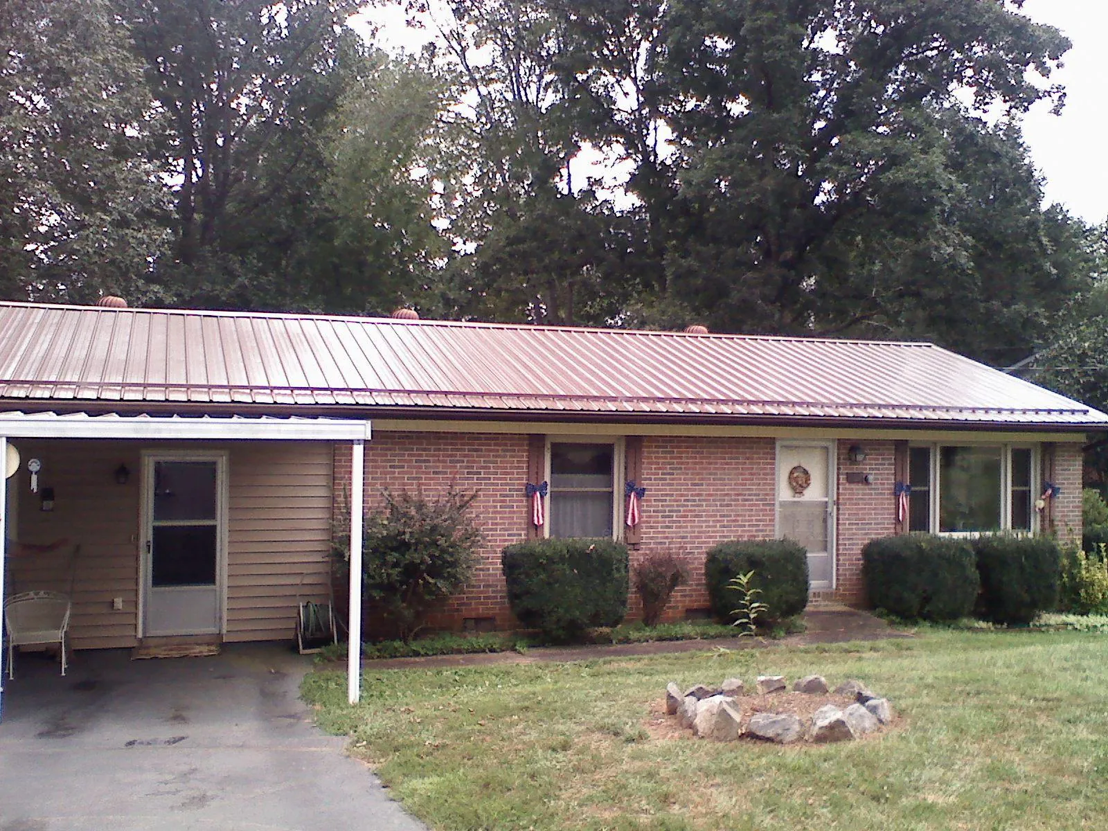 Bronze metal roof and carport on a brick ranch home in Alloy