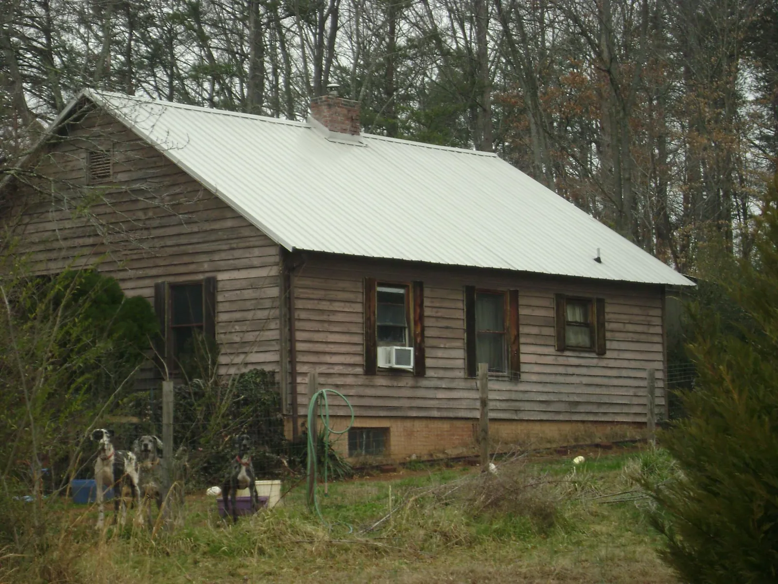 White metal roof on an old wood sided farmhouse, from a Metal Roof Installation job in Alloy